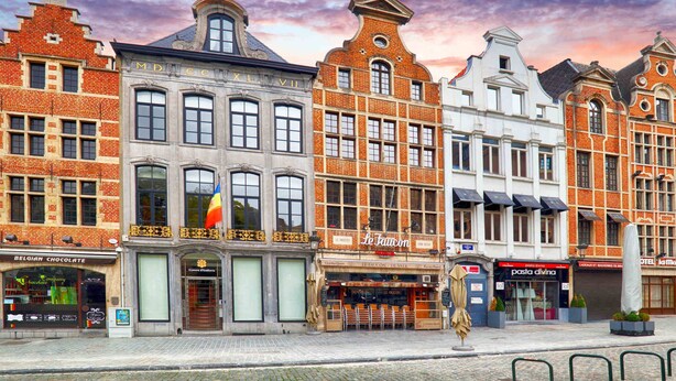 Una hilera de edificios europeos históricos con una calle adoquinada al frente.