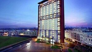 A tall hotel building with a modern design, featuring multiple floors and a prominent entrance. - Atria Residences Gading Serpong (Gading Serpong)