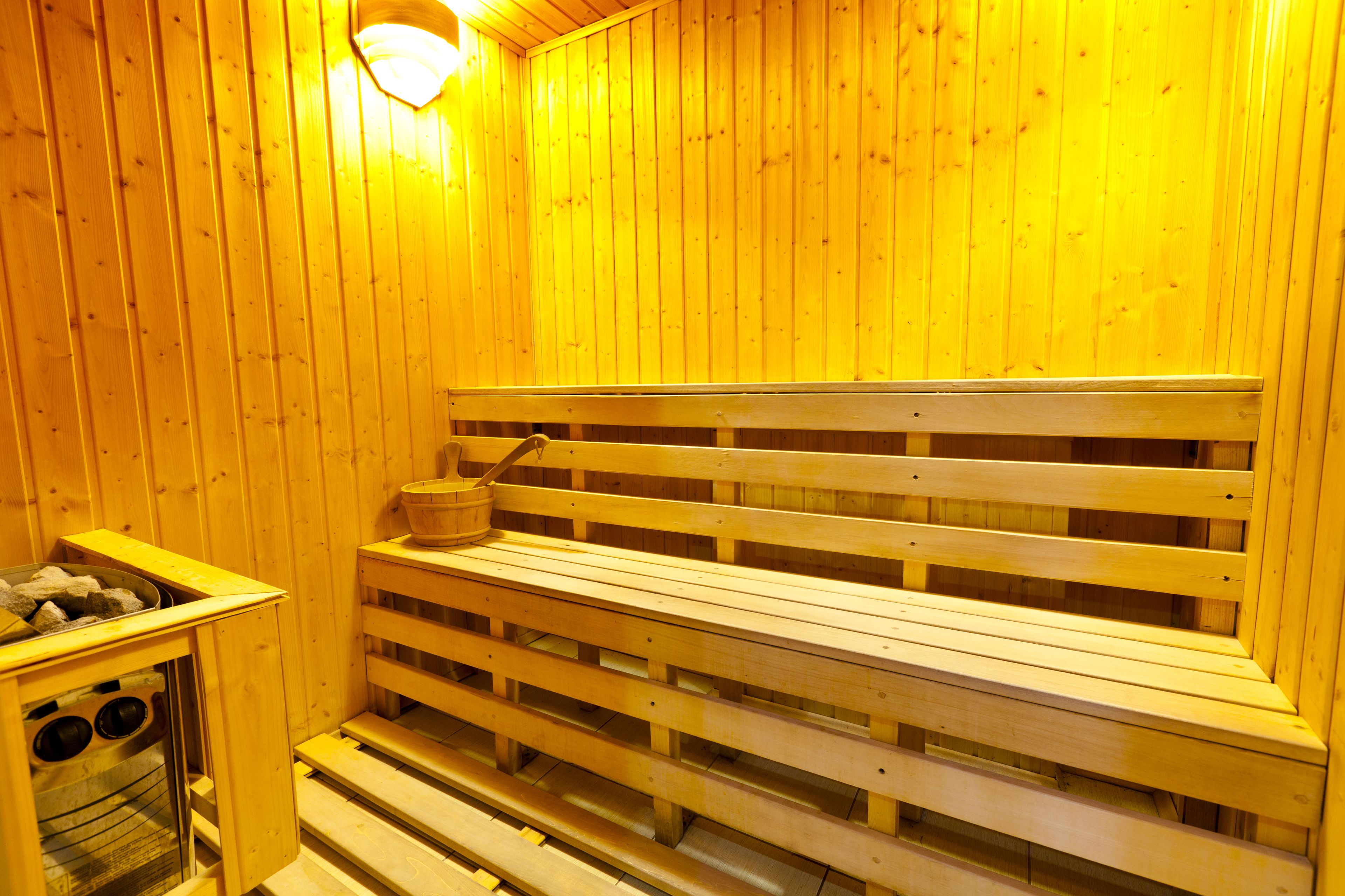 A wooden sauna with benches and a stone basin.