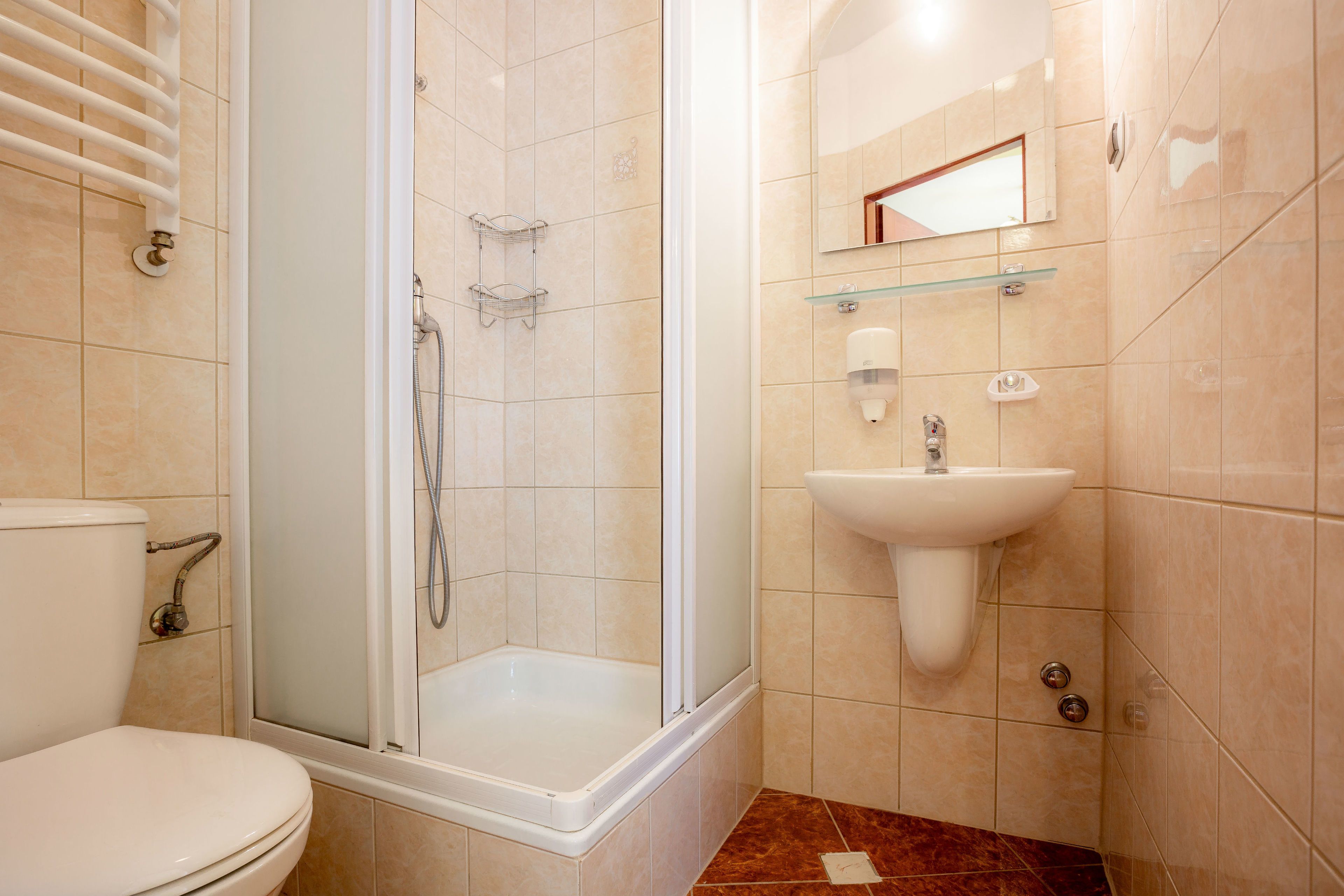 Un baño moderno con cabina de ducha, inodoro y lavabo con espejo.