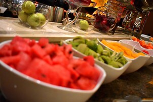 Una mesa de buffet con diversas frutas y bebidas.