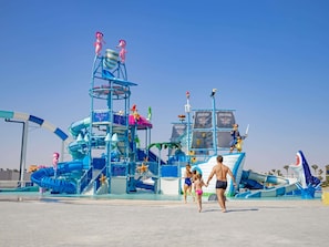 A water park with a large slide, a pirate-themed structure, and a sandy area. - Mövenpick Waterpark Resort & Spa Soma Bay (Soma Bay)