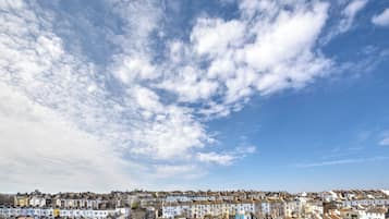 A densely packed residential area with uniform row houses under a partly cloudy sky.