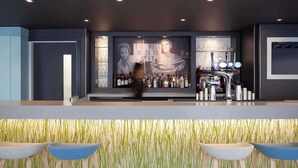 A bar area with a counter, bar stools, a large poster, and a bar stocked with bottles.