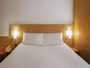 A hotel room with a large bed, two bedside lamps, and a wooden headboard. - Hotel ibis Lagos Ikeja (Lagos)