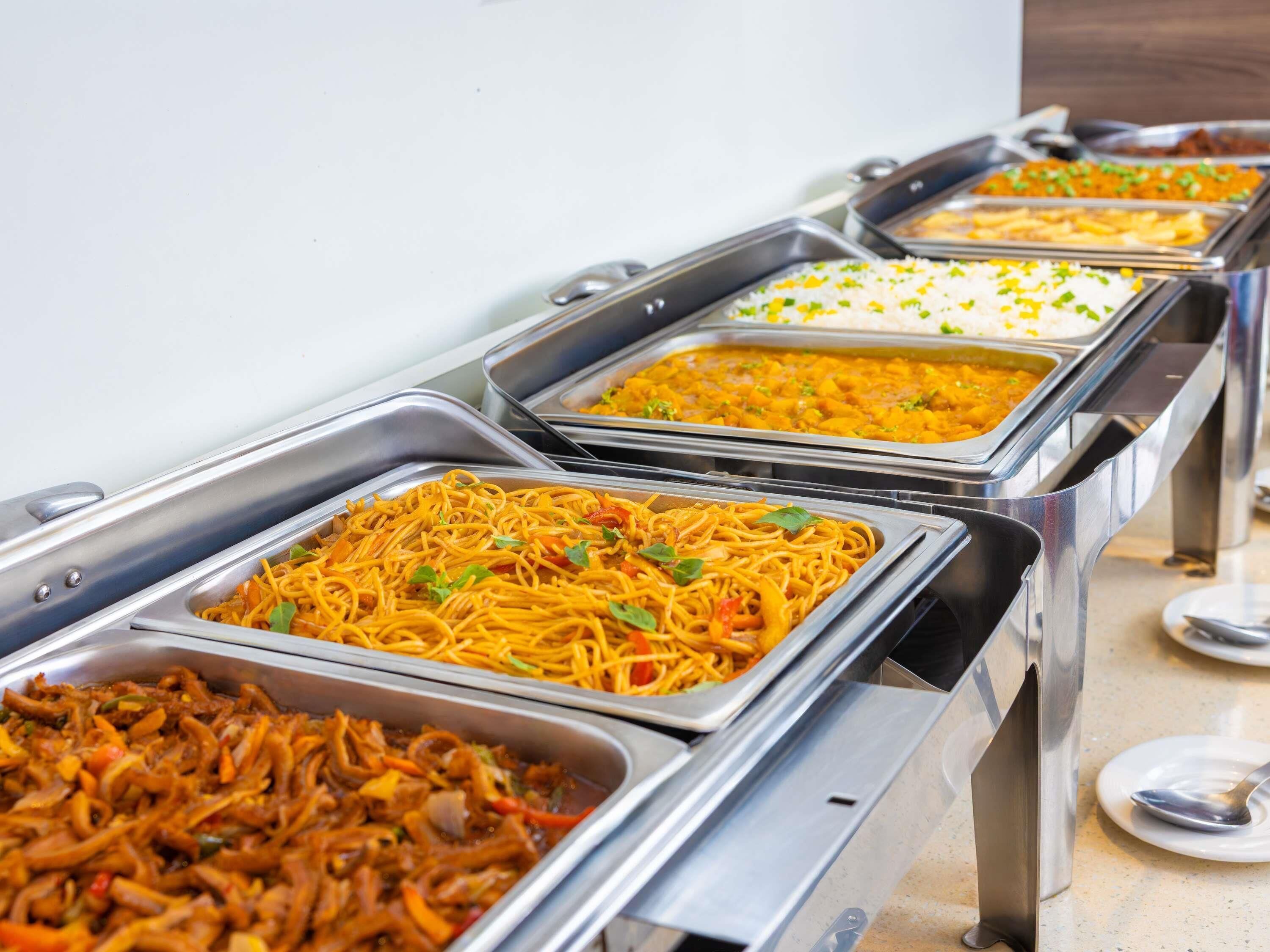 Ein abwechslungsreiches Buffet mit Speisen wie Nudeln, Reis und gebratenem Gemüse.