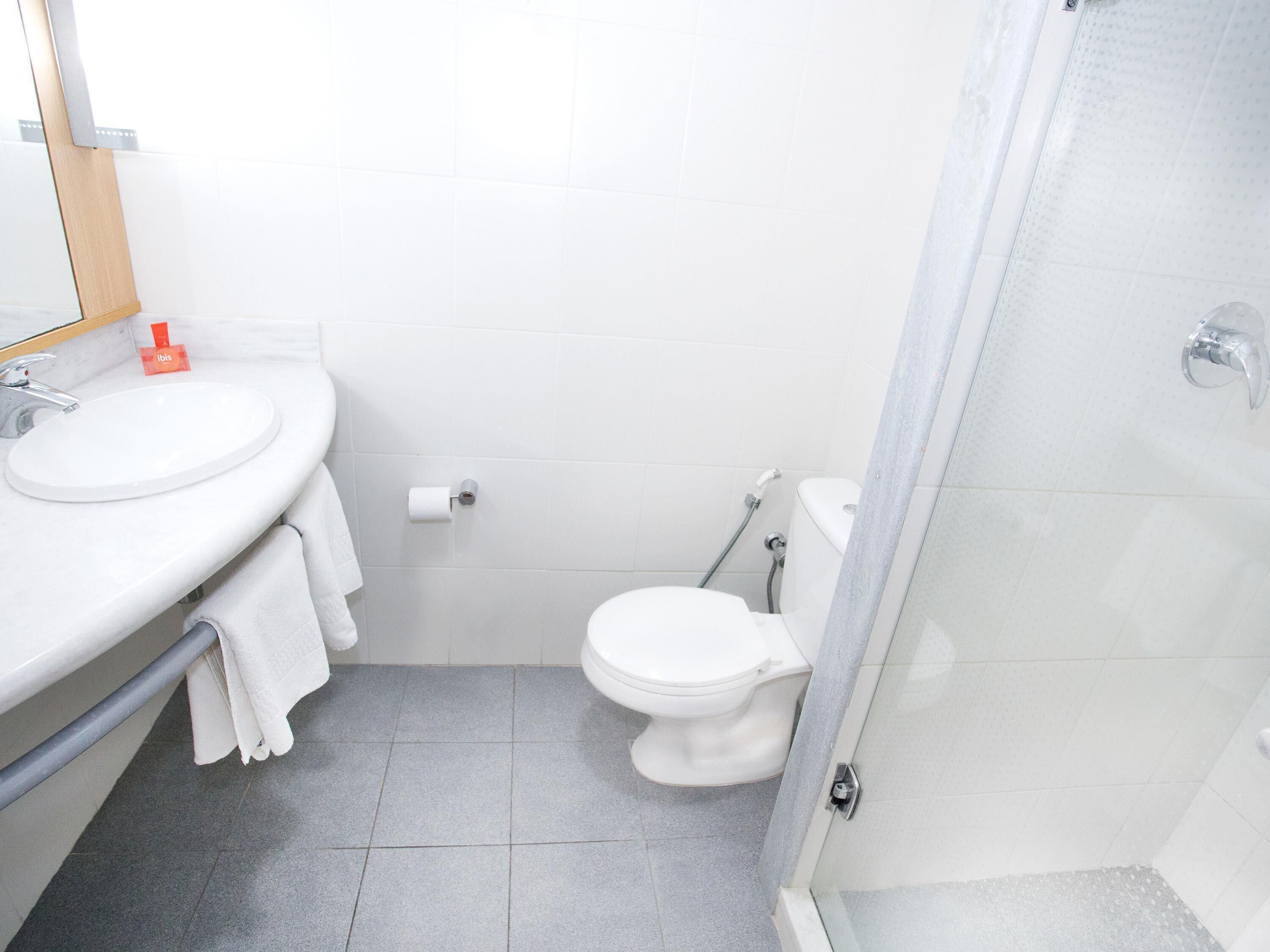 Un baño con lavamanos, inodoro y ducha.