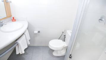 Un baño con lavamanos, inodoro y ducha.