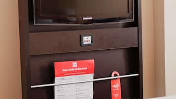 A hotel minibar with a Samsung TV, a minibar card, and a red tag.