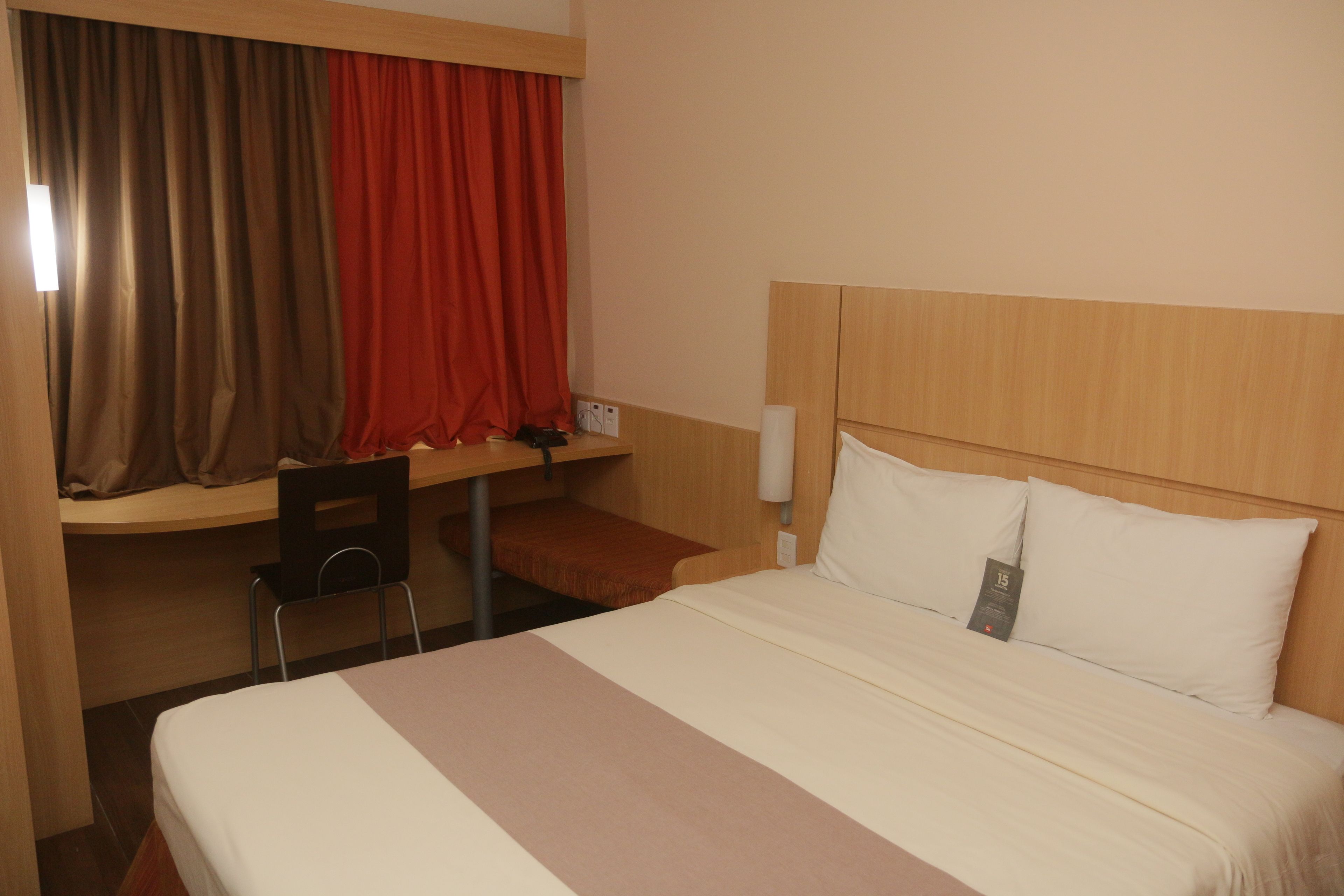 Ein Hotelzimmer mit einem Bett, einem Schreibtisch und einem Stuhl.