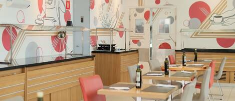 A modern restaurant interior with a counter, seating area, and abstract wall art.