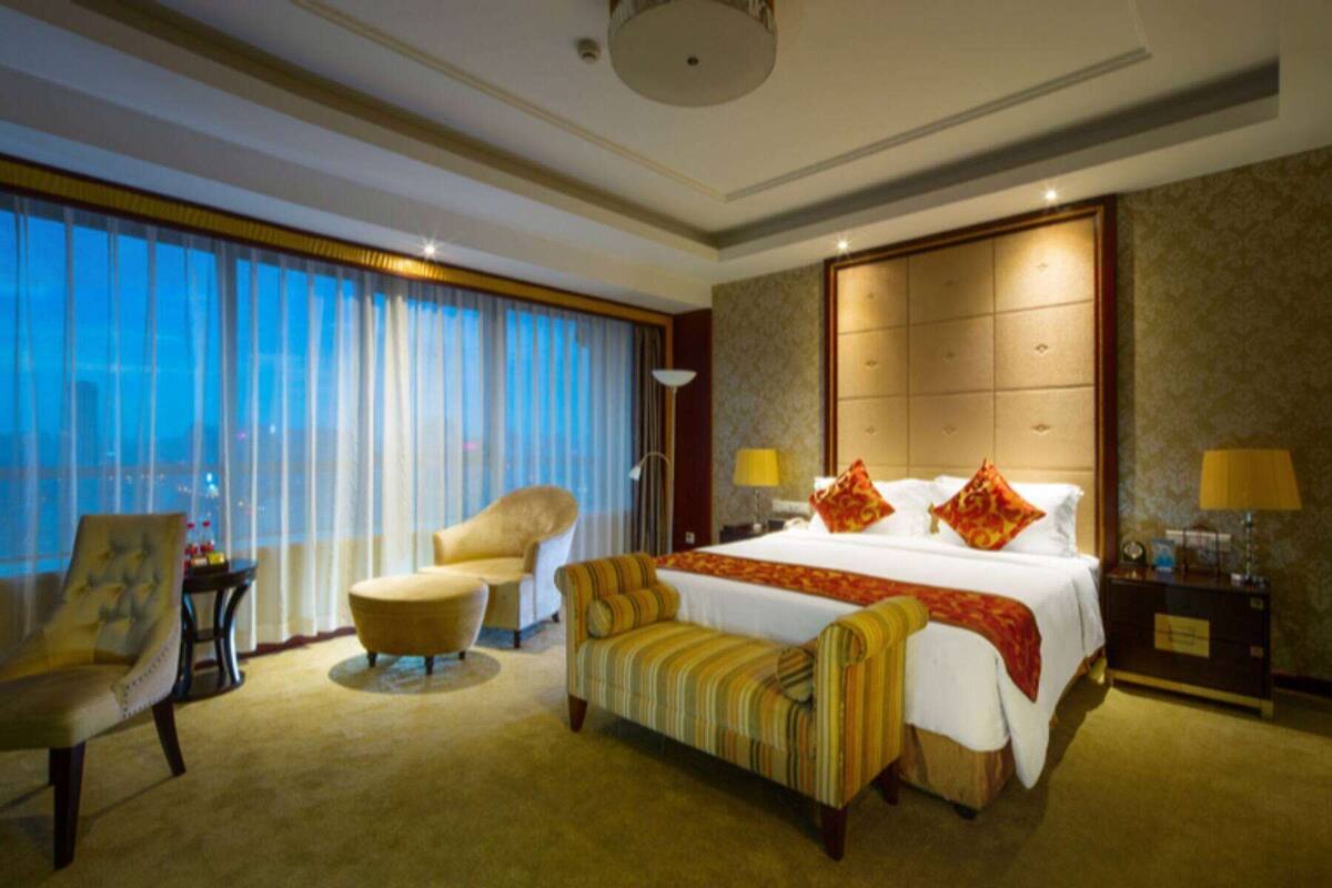 Ein Hotelzimmer mit einem großen Bett, einer Couch, einem Sessel und einem Schreibtisch.