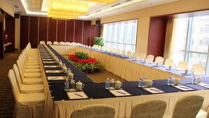 A conference room with a long table, chairs, and a chandelier.