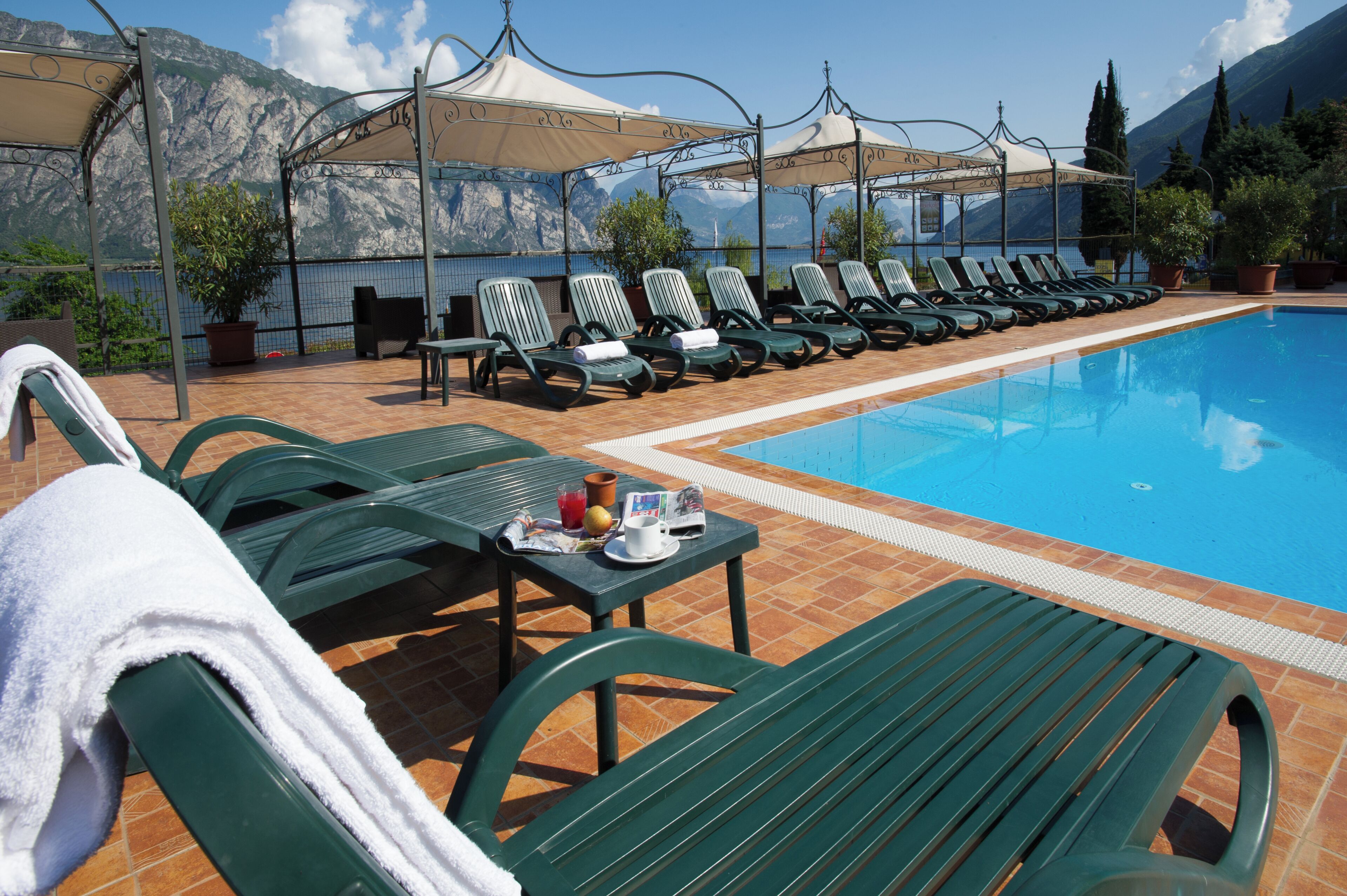 Una piscina al aire libre, sillones reclinables de piscina