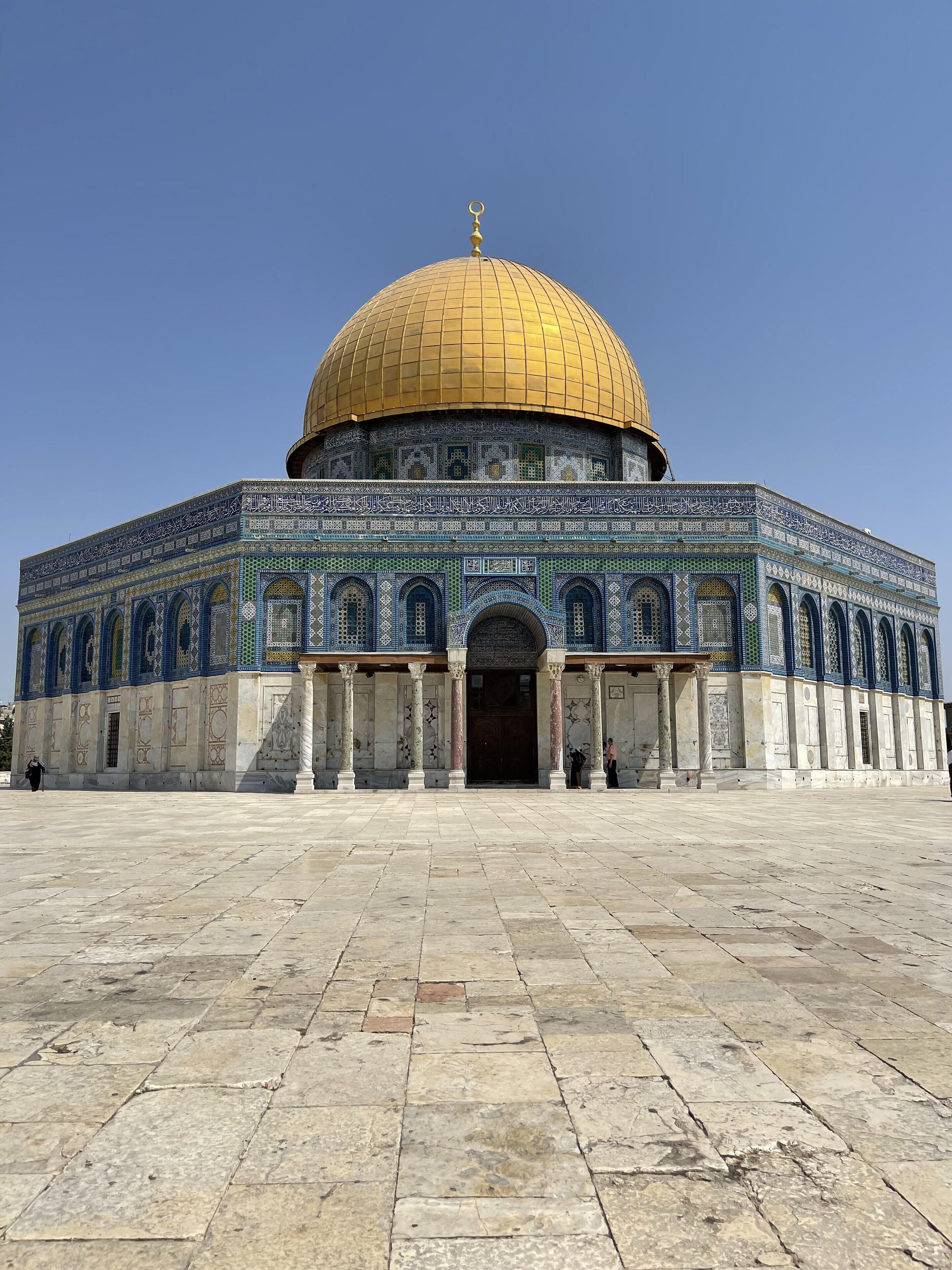 A large, historic building with a golden dome and intricate tile work.
