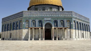 A large, historic building with a golden dome and intricate tile work.