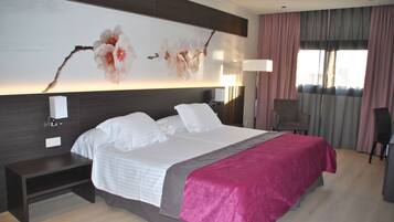 Een moderne hotelkamer met een groot bed, een nachtkastje, een bureau en een stoel.