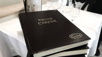 Un libro negro con el título 'Ristorante CARPINI' y un logotipo que indica 'CARPINI Group desde 1994'.