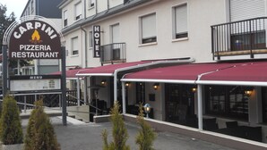 Un edificio con un letrero que dice 'Carpini Pizzeria Restaurant' y un letrero de 'Hotel'.
