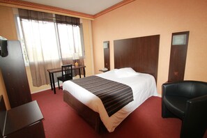 A hotel room with a large bed, a desk, a chair, and a TV. - Adonis Lyon Est Hôtel Artys (Saint-Priest)