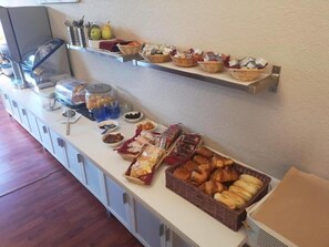 A buffet setup with various food items and condiments. - Adonis Lyon Est Hôtel Artys (Saint-Priest)