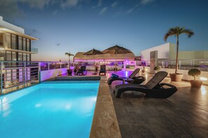 A modern pool area with lounge chairs and a covered seating area. - Soho Playa Hotel (Playa del Carmen)