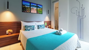 Une chambre d’hôtel moderne avec un grand lit, une vue sur la mer et un élément décoratif mural.