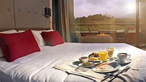 A hotel room with a bed, breakfast tray, and a view of the outdoors. - Hotel K10 (Urnieta)