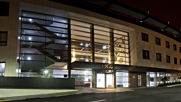A modern hotel with a glass facade, a prominent entrance, and a sign reading "HK10 HOTEL". - Hotel K10 (Urnieta)