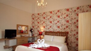 Une chambre d’hôtel avec un lit, une télévision, un bureau et une chaise.