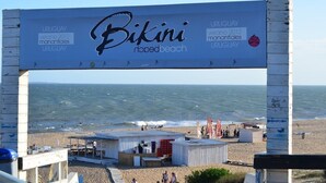 A beach with a large billboard advertising 'Bikini nopedbeach'. - Hotel Florinda (Punta del Este)