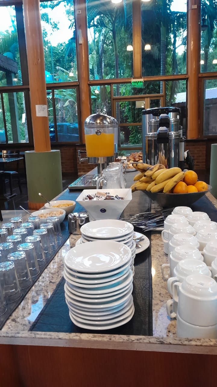 A breakfast buffet with various food items and beverages, including fruits, cereals, and coffee.