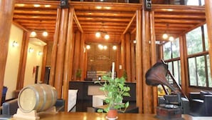 Een houten interieur met een receptiebalie, kamerplanten en een bar.