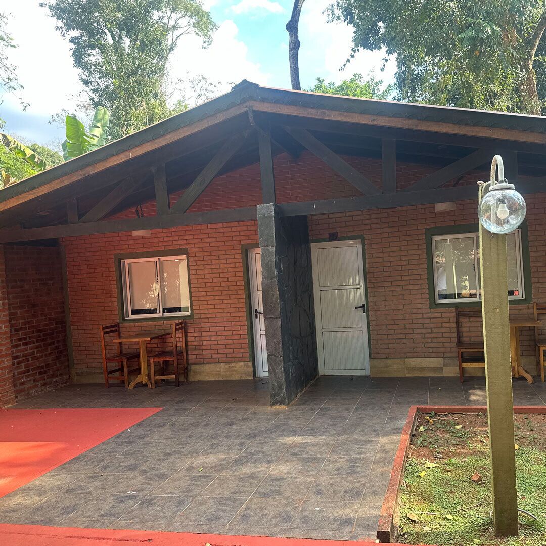 Een bakstenen gebouw met een overdekte patio, een deur en een raam.