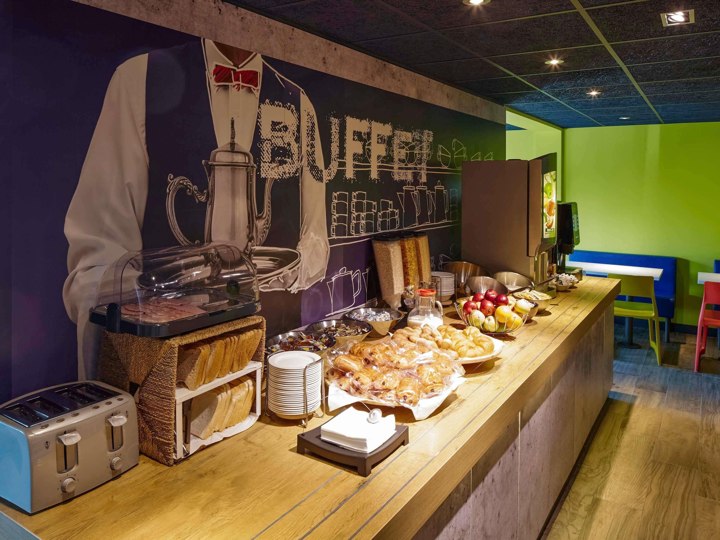 A breakfast buffet with various food items, a coffee machine, and a toaster.