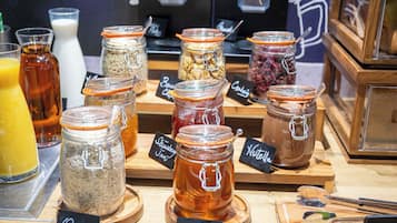 A display of various food items in jars with labels, including oats, honey, and jam.