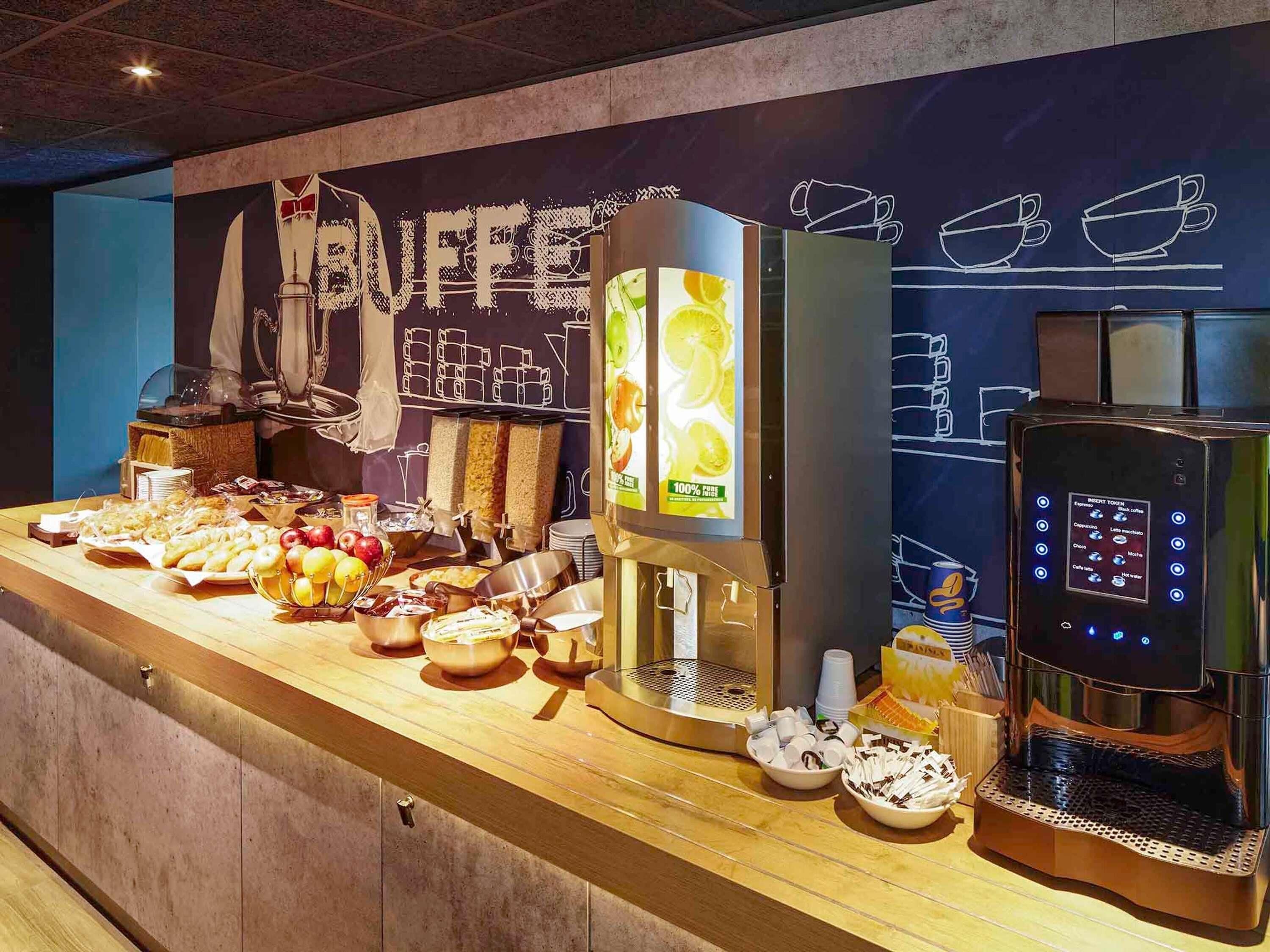 Ein Buffet mit verschiedenen Speisen, einer Kaffeemaschine und einem Getränkespender.