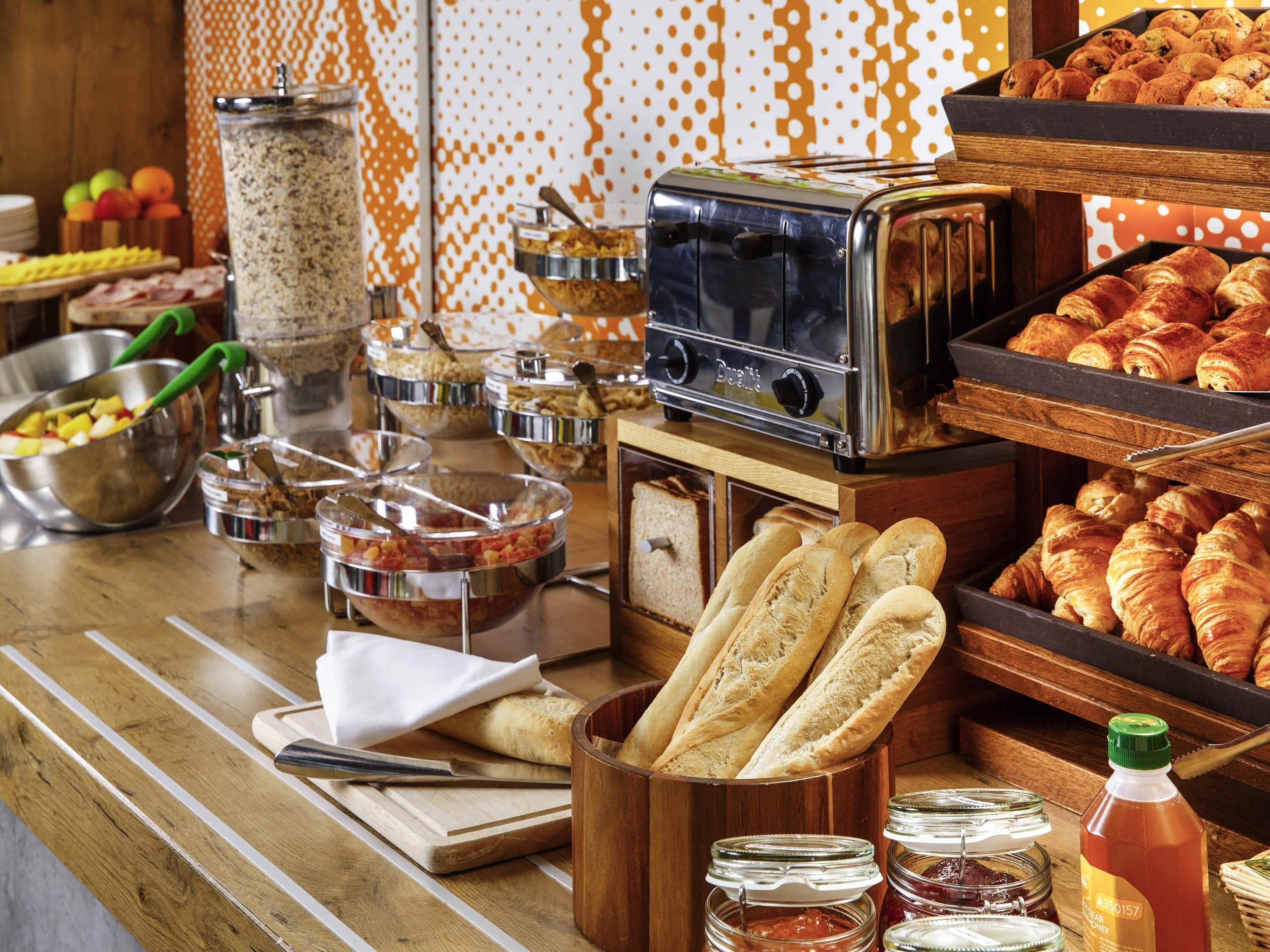 Een buffetopstelling met diverse gerechten, een broodrooster en sauzen.