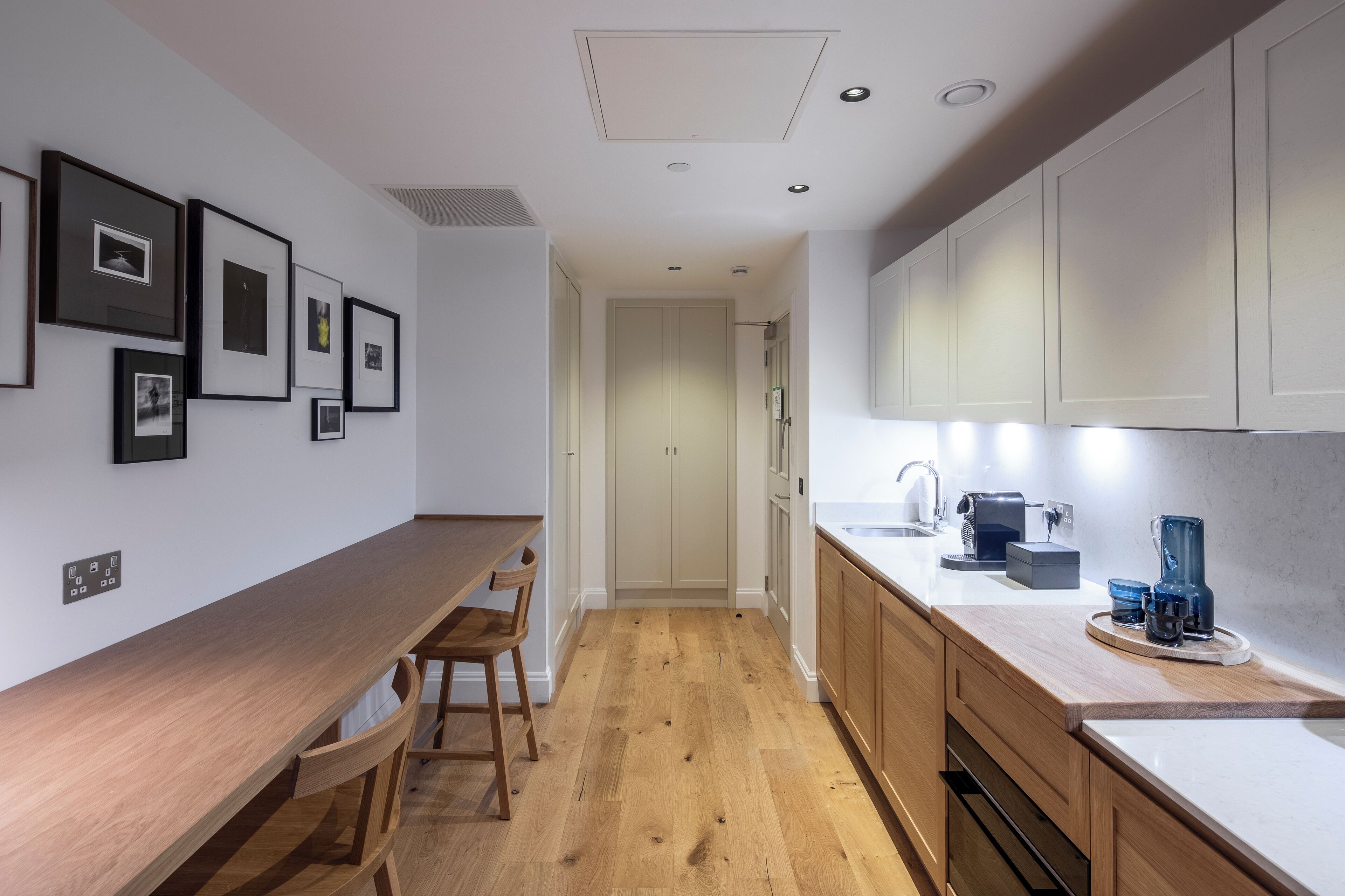 Una cocina moderna con encimeras de madera, horno empotrado y cafetera.