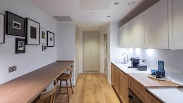 Una cocina moderna con encimeras de madera, horno empotrado y cafetera.