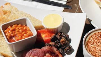 A breakfast plate with bacon, eggs, beans, and toast.