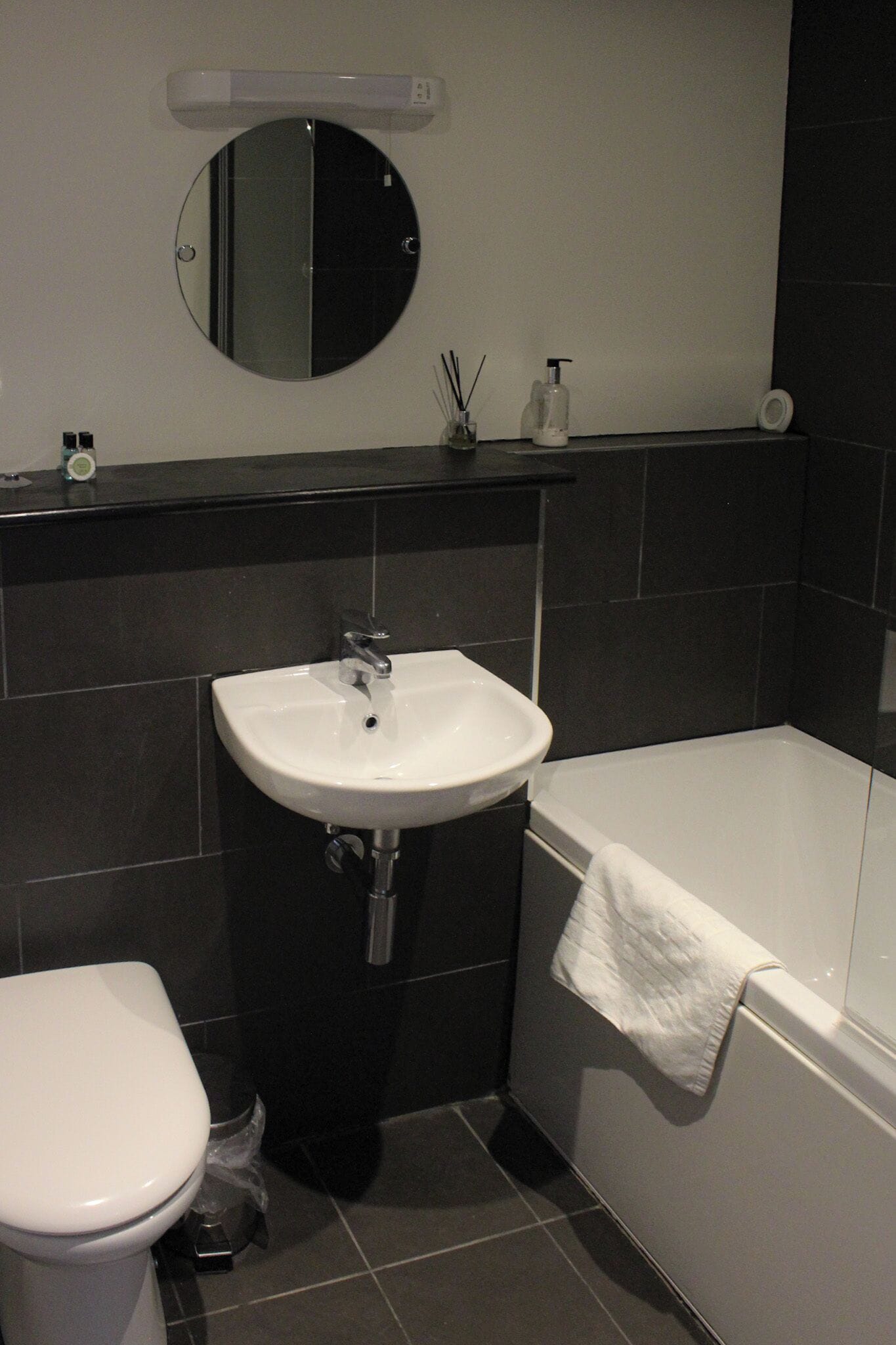 Un baño con lavamanos blanco, inodoro y bañera.