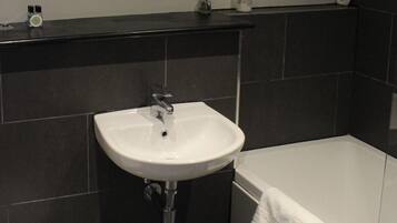Un baño con lavamanos blanco, inodoro y bañera.