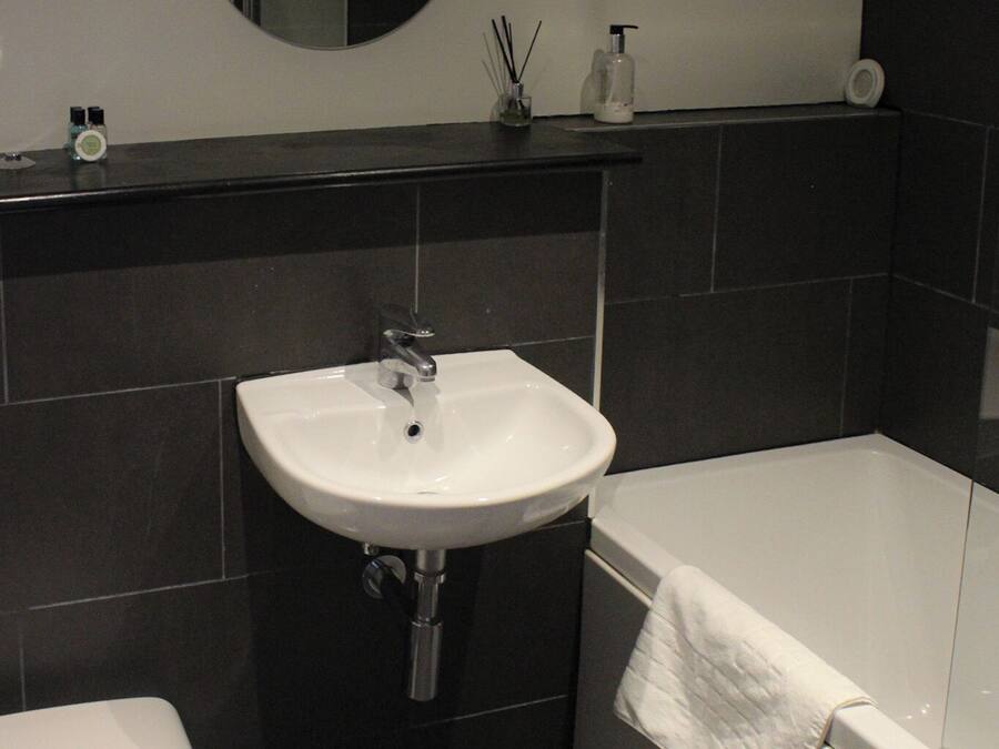 Un baño con lavamanos blanco, inodoro y bañera.