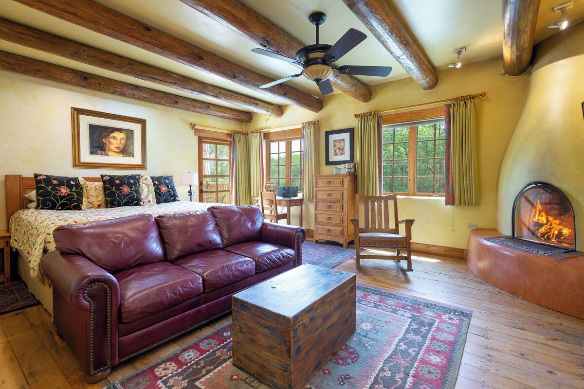 A cozy living room with a leather sofa, a wooden coffee table, and a fireplace.