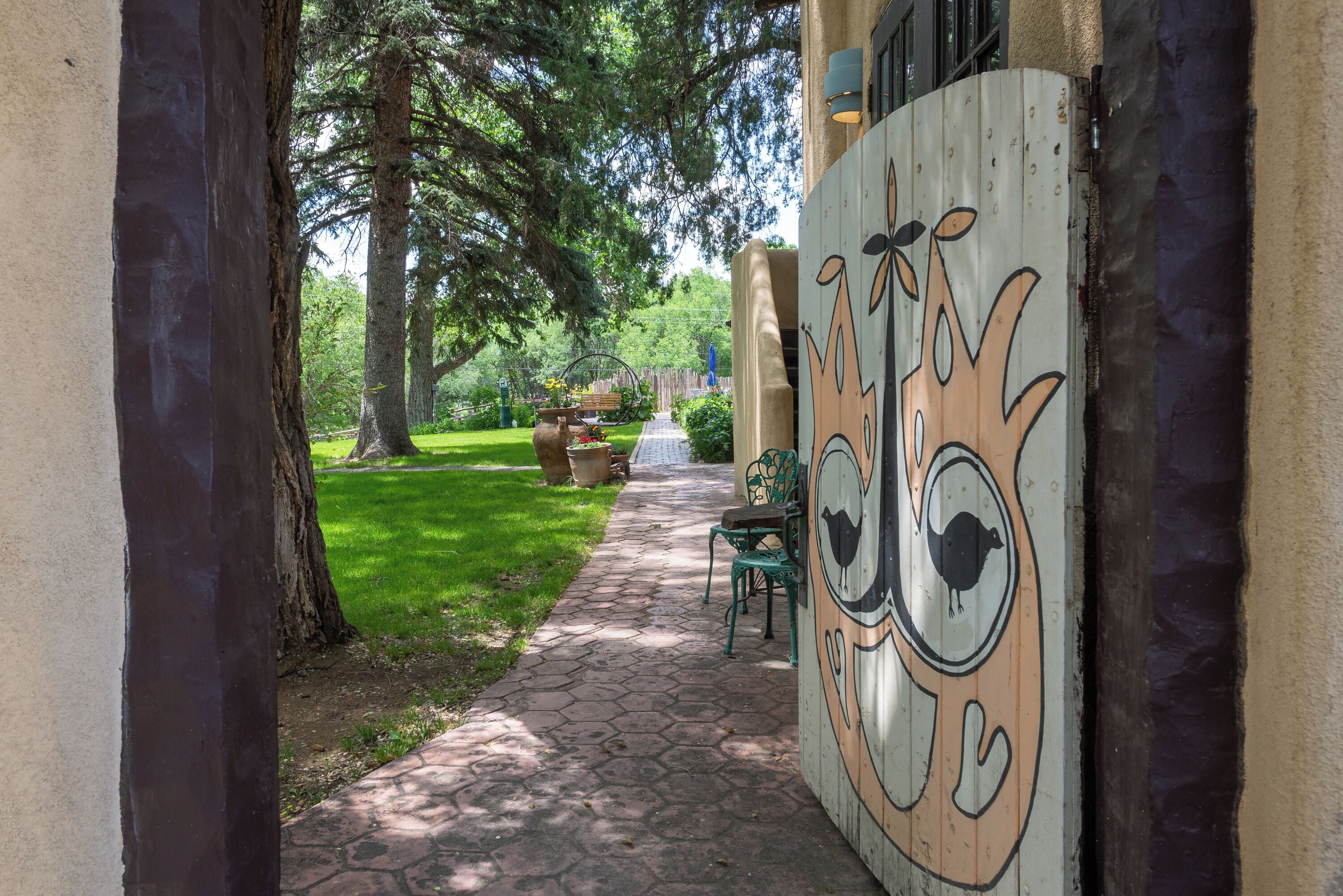 Un sendero que conduce a un edificio con un mural de un pájaro.