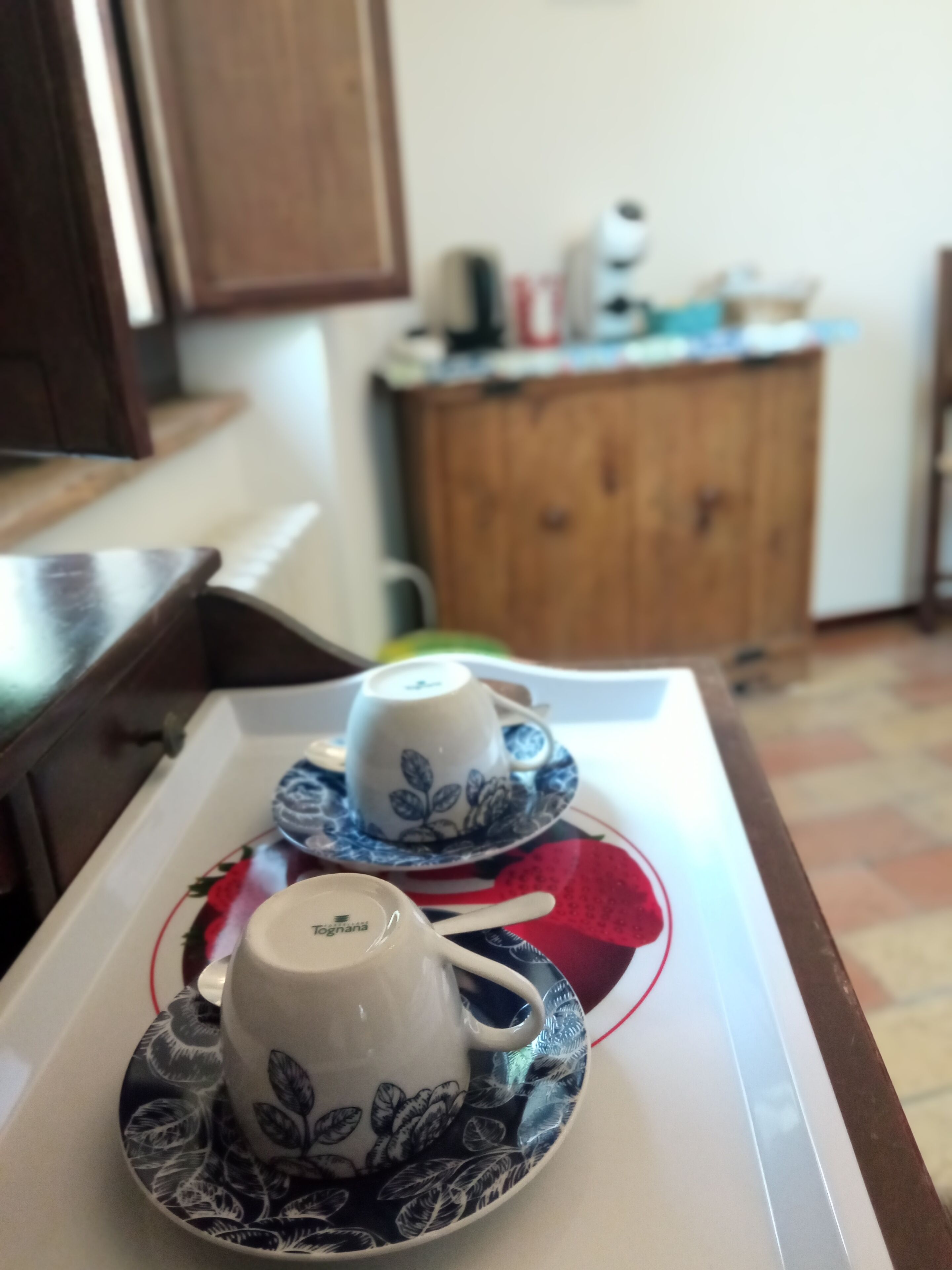 Un plateau avec deux tasses et leurs soucoupes, posé sur une table.