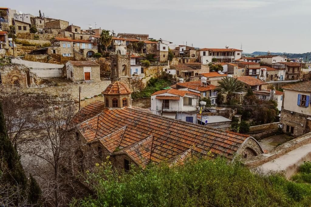 A hillside village with traditional architecture, terraced roofs, and a prominent church.