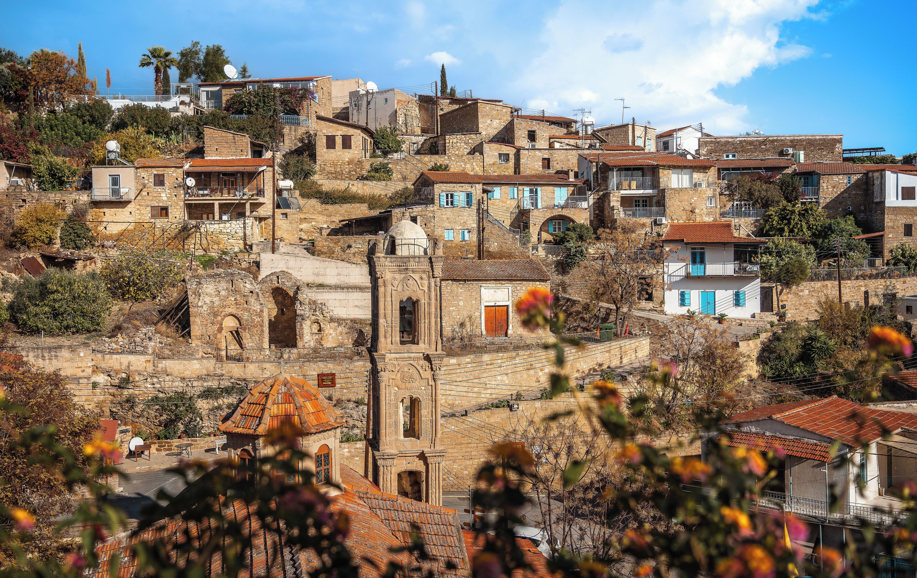 Un village perché sur une colline, avec des bâtiments en pierre, dont certains sont dotés de balcons et d’antennes paraboliques.