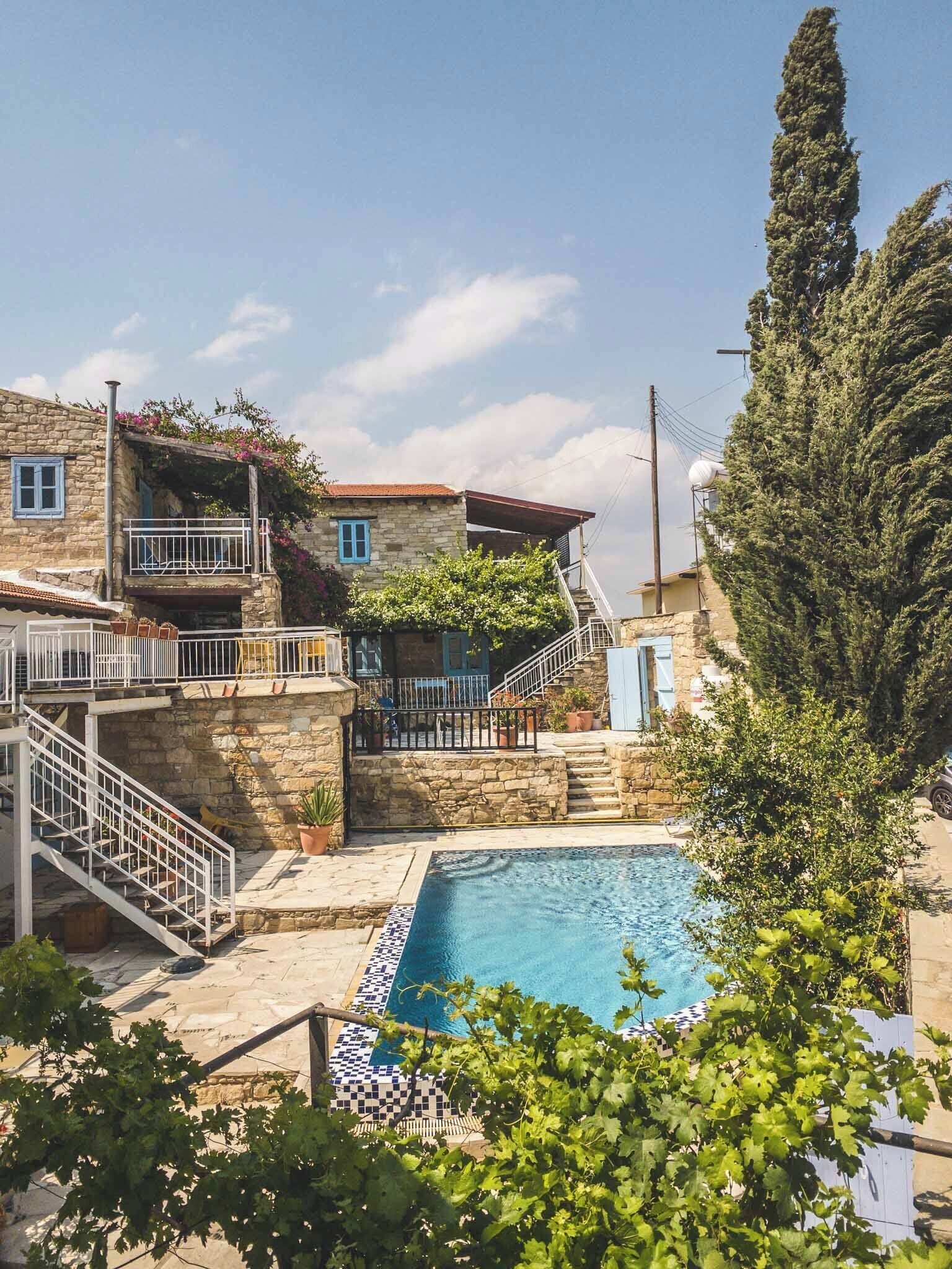 A stone building with a pool, stairs, and a balcony.